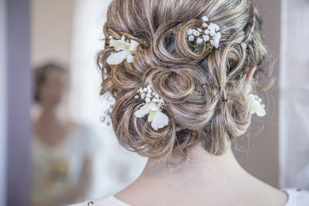 Bridal Hairstyle & Hair cutting salon near me Brampton Close-up of an elegant bridal hairstyle featuring delicate white flowers, perfect for a wedding day.